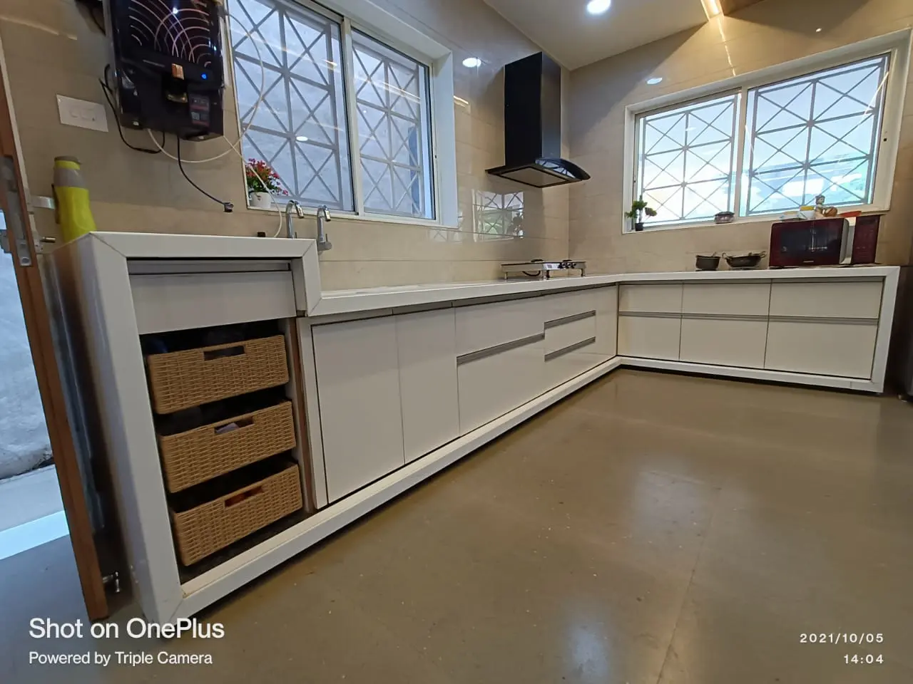 a kitchen with white cabinets and a black stove showing best interior design pune