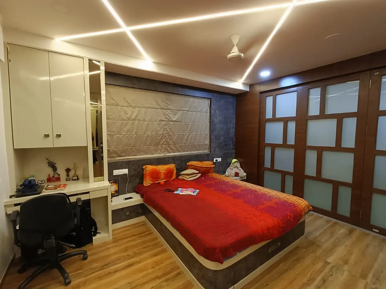 a room with a bed and a study table showing best interior design pune