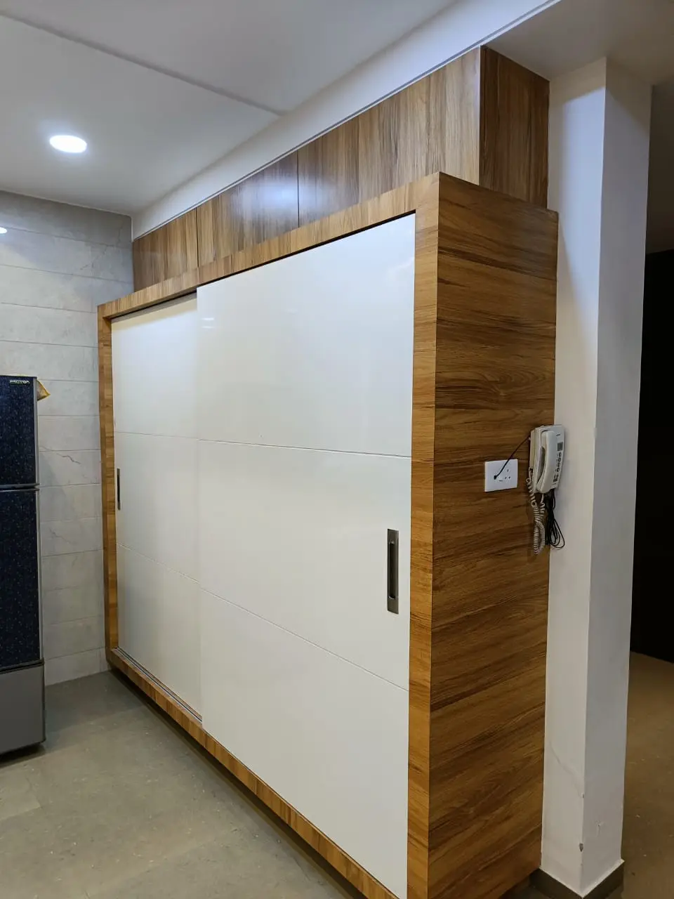 a unique wardrobe with white and wooden combination showing best interior design pune